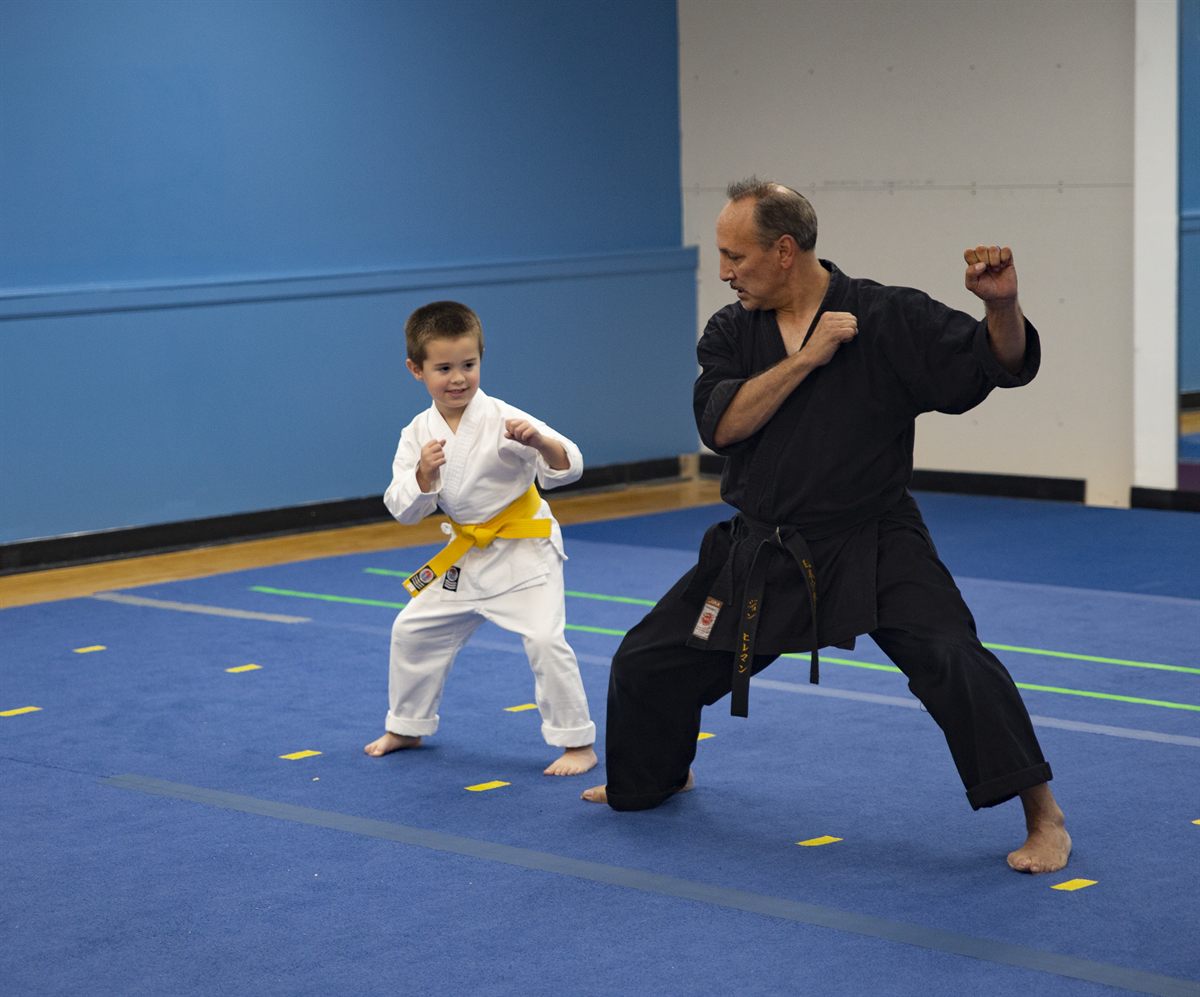 Instructor coaching a young karate student