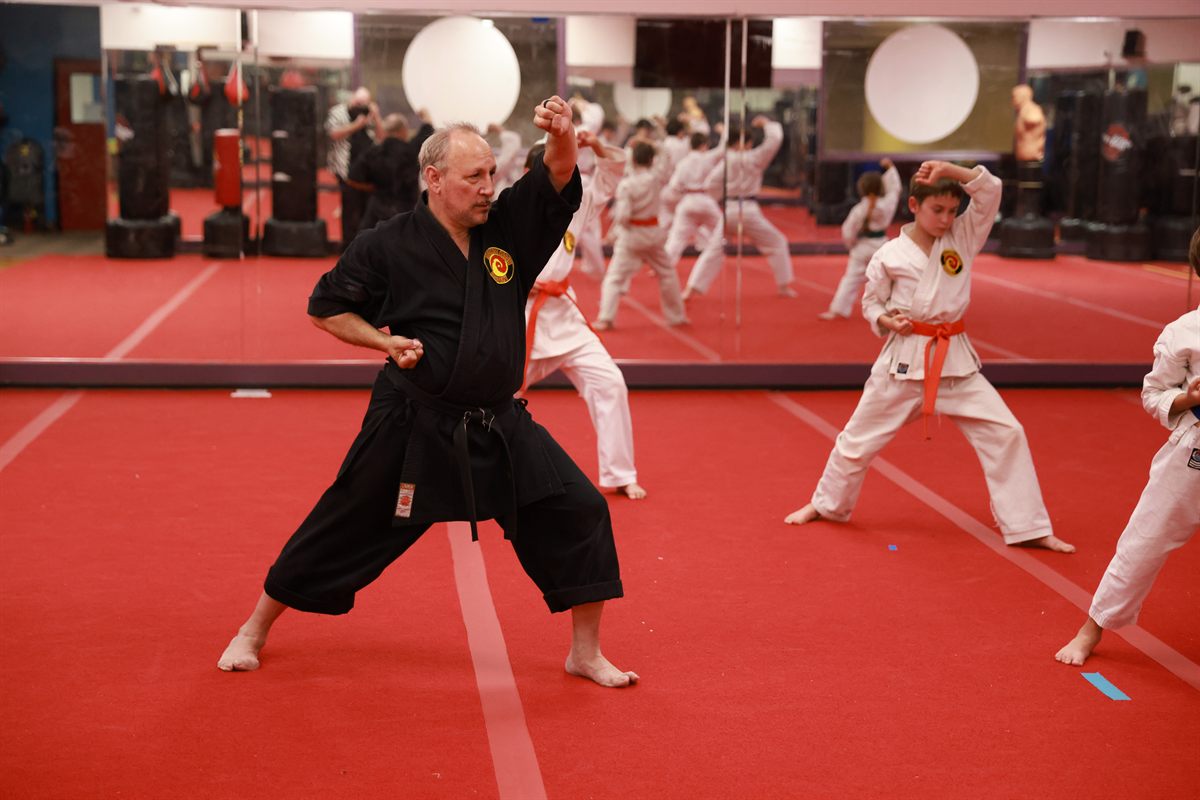 Instructor leading karate students through stance work